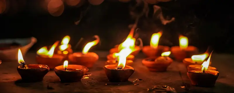 Clay diyas glowing on a dark Diwali night