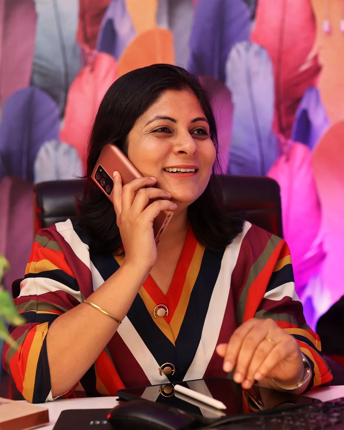 Illustrative scene: a smiling businesswoman on a phone call at her desk