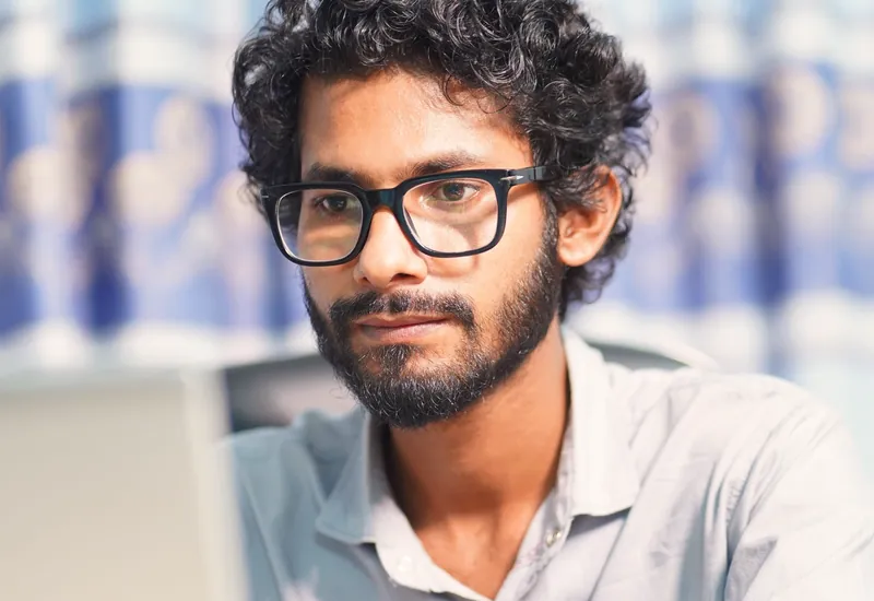 Illustrative scene: a man focused on his laptop