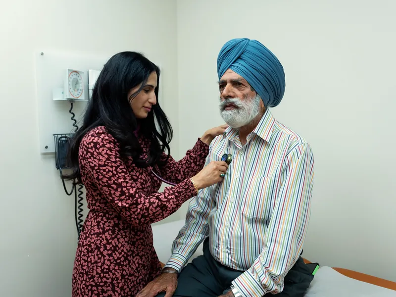 Illustrative scene: a doctor examining an elderly patient with a stethoscope