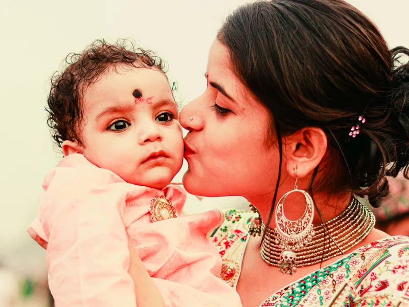 Illustrative scene: a mother kissing her baby