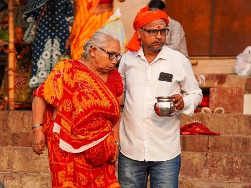Illustrative scene: a man helping an elderly woman walk along temple steps