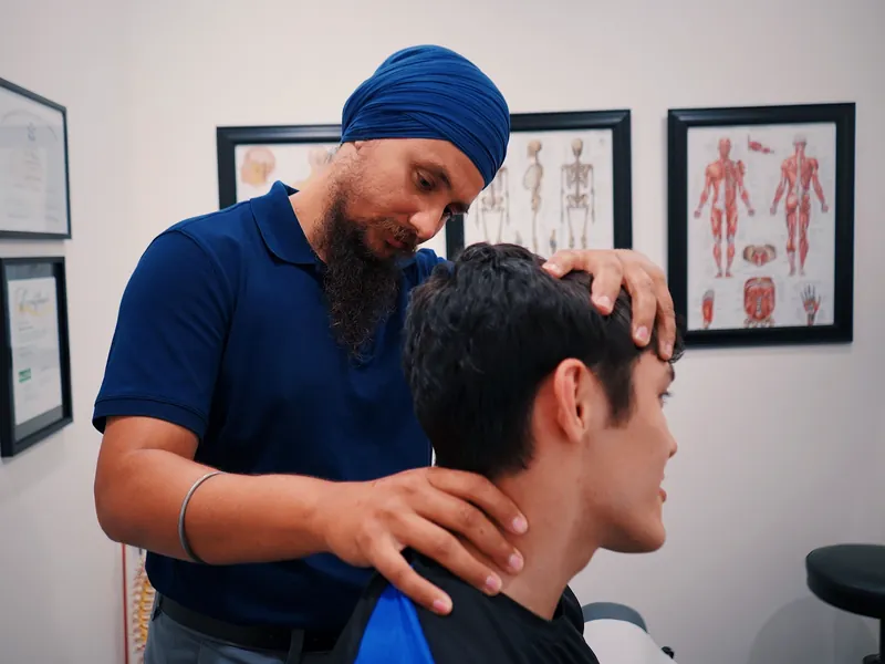 Illustrative scene: a physiotherapist examining a patient's neck in a clinic
