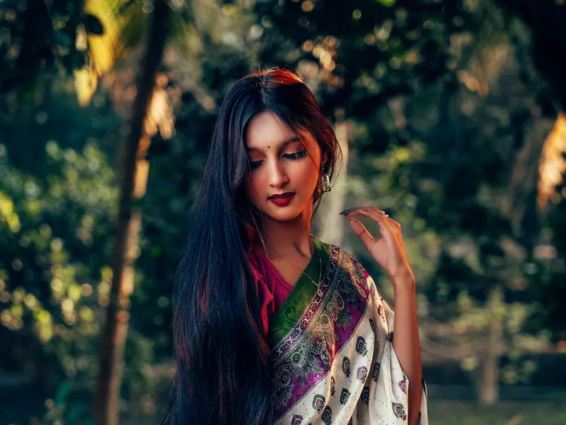 Illustrative scene: a woman with long hair in a saree standing in a garden