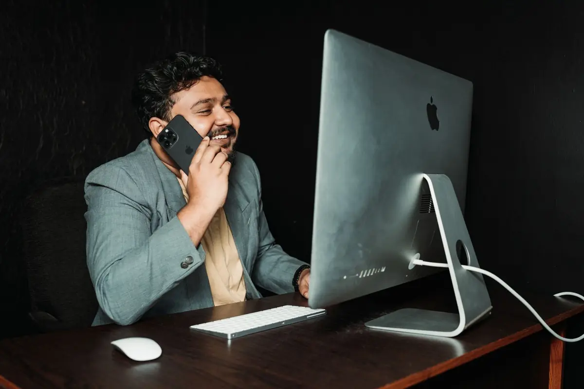 A man on a phone call at an office desk, illustrative scene