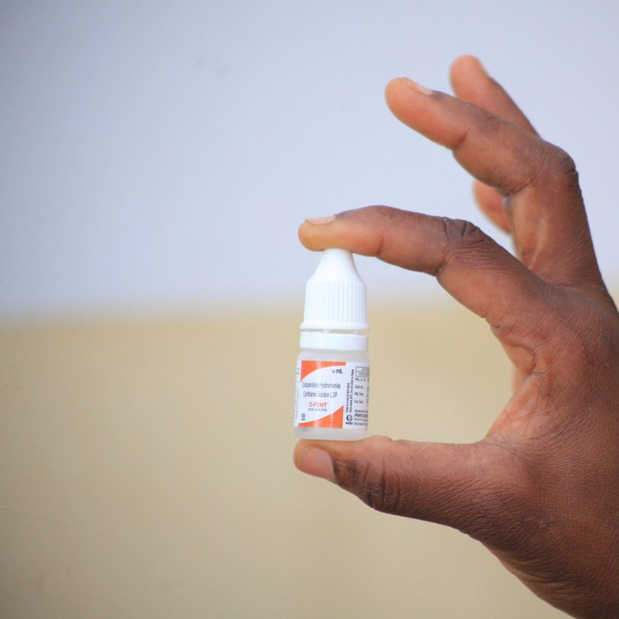 Hand holding an eye drop bottle